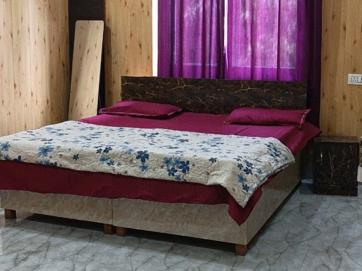 Double bed with floral bedspread beside the window